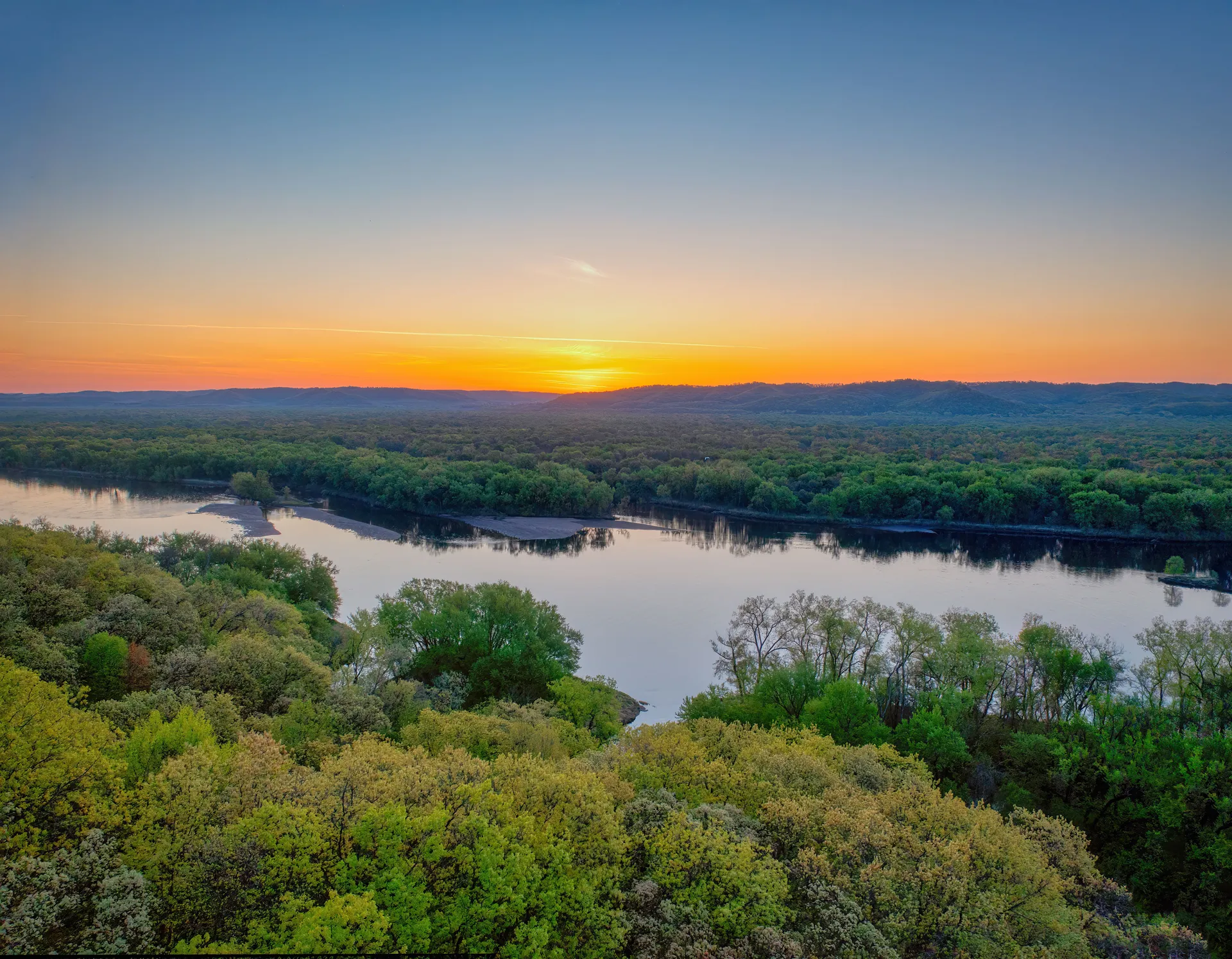 Sunset over a wooded Minnesota river valley, Minnesota Radon Pros